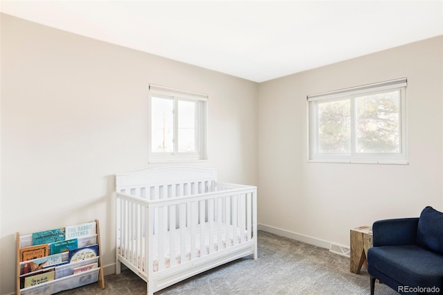 carpeted bedroom with a nursery area and baseboards