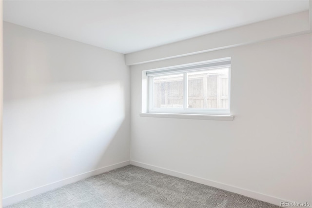 spare room with light colored carpet and baseboards