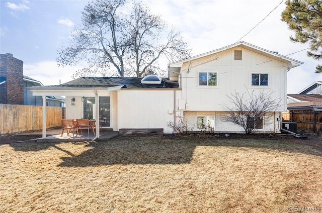 back of property with central air condition unit, a patio area, fence, and a lawn