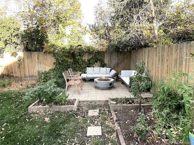 view of patio featuring a fenced backyard, a vegetable garden, and an outdoor living space with a fire pit