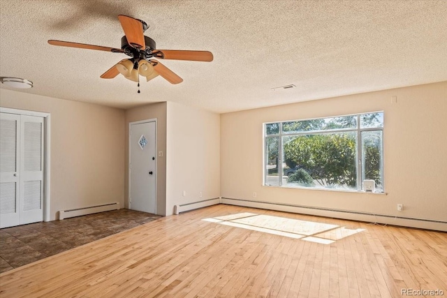 empty room with ceiling fan, a textured ceiling, a baseboard heating unit, and wood-type flooring