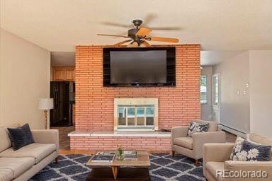 living area featuring ceiling fan and a brick fireplace