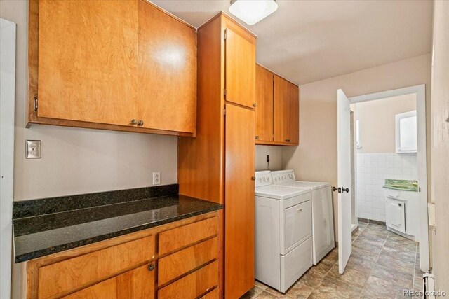 laundry room with washer and dryer, tile walls, and cabinet space