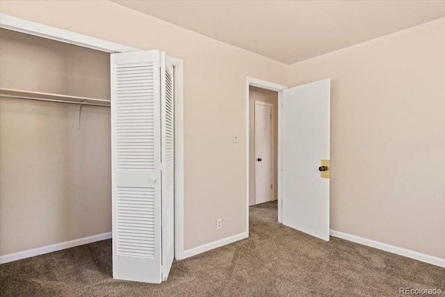 unfurnished bedroom featuring a closet, carpet flooring, and baseboards