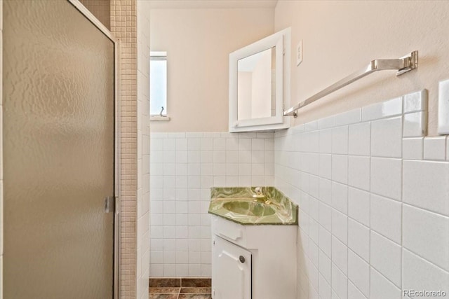 bathroom featuring vanity, tile walls, and a stall shower