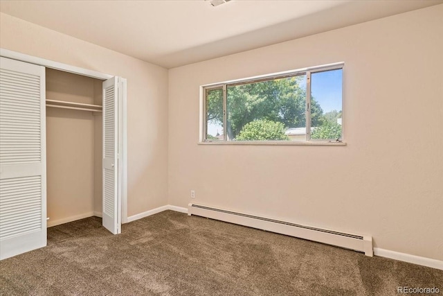 unfurnished bedroom with baseboards, a baseboard heating unit, dark carpet, and a closet
