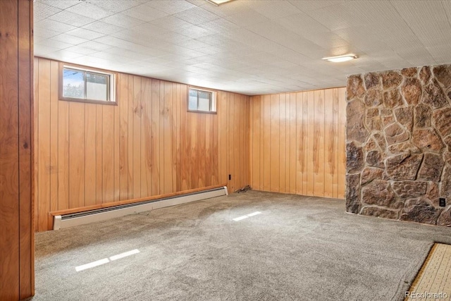 basement featuring wood walls, baseboard heating, and carpet floors
