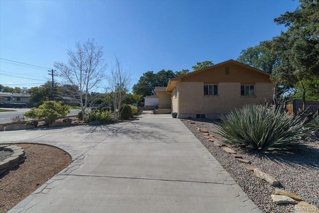 view of home's exterior with brick siding and driveway