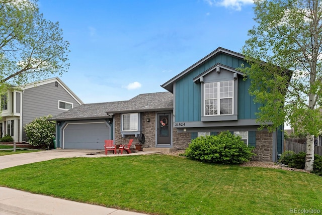 split level home with stone siding, a garage, a front lawn, board and batten siding, and driveway