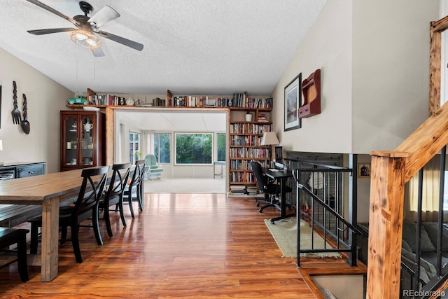 dining room featuring a ceiling fan, a textured ceiling, and wood finished floors