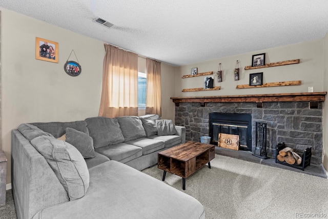 carpeted living room with a textured ceiling, visible vents, and a stone fireplace