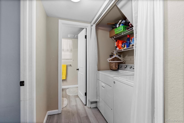 laundry area with separate washer and dryer, light wood finished floors, and baseboards