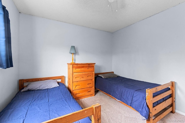 bedroom featuring a textured ceiling, ceiling fan, and carpet floors