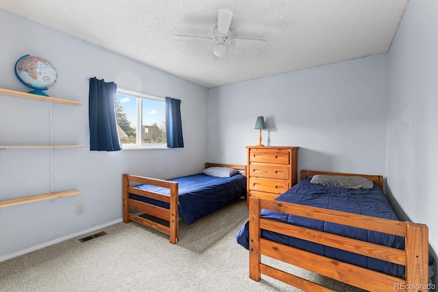 carpeted bedroom with ceiling fan, visible vents, and a textured ceiling