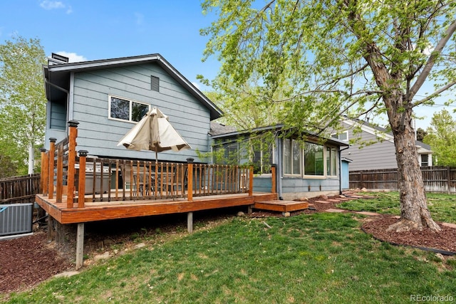 rear view of house featuring cooling unit, a chimney, fence, a deck, and a yard