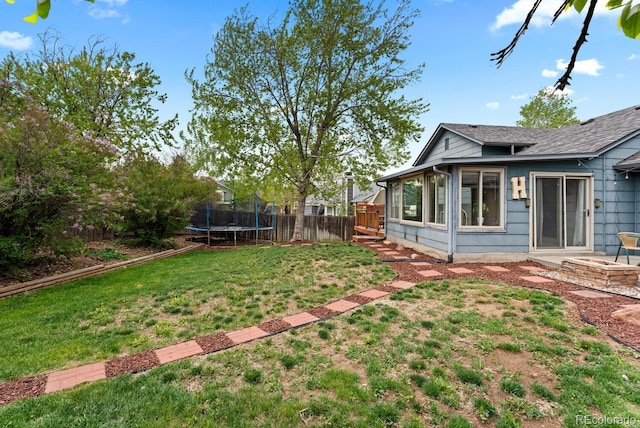 view of yard with a fenced backyard and a trampoline