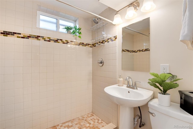 bathroom featuring a tile shower and toilet