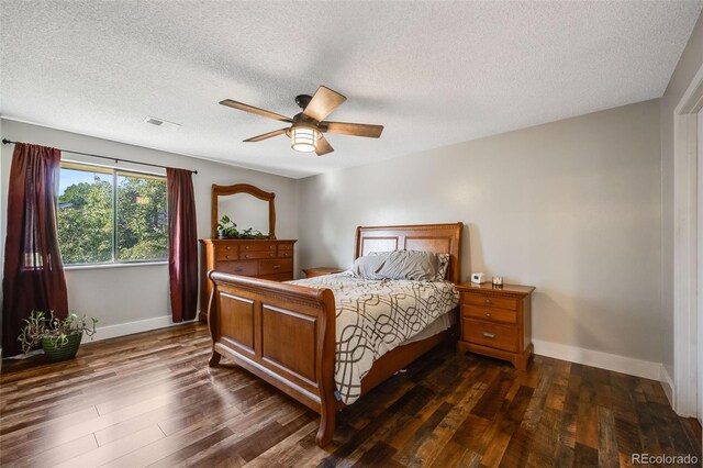 bedroom with dark wood-type flooring, ceiling fan, and a textured ceiling