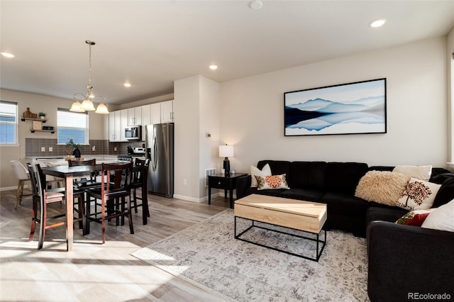 living area featuring light wood-style flooring, recessed lighting, and baseboards