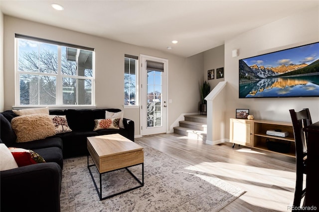 living room featuring stairs, recessed lighting, wood finished floors, and baseboards