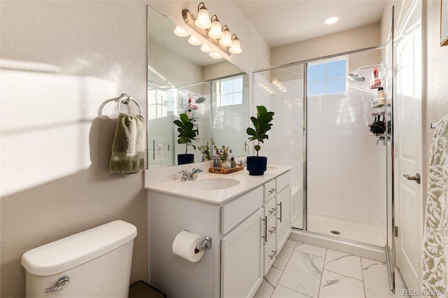 bathroom featuring marble finish floor, a stall shower, vanity, and toilet