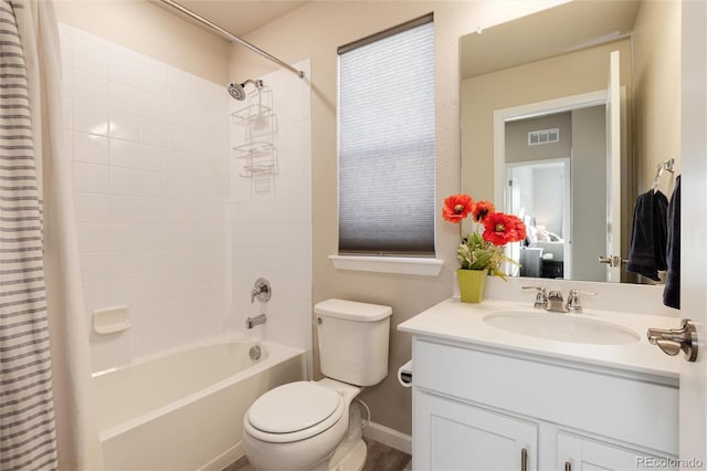 bathroom featuring visible vents, shower / bath combo with shower curtain, toilet, baseboards, and vanity