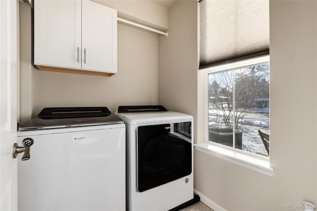 laundry room featuring washer and dryer, baseboards, and cabinet space