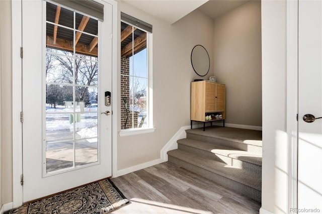 doorway with baseboards and wood finished floors