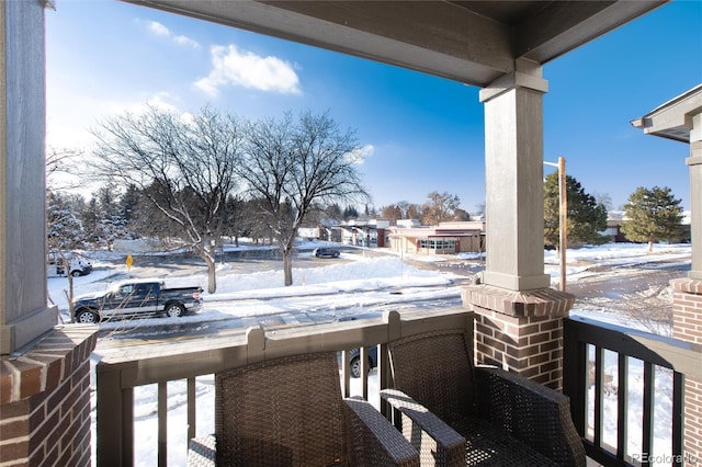 view of snow covered back of property