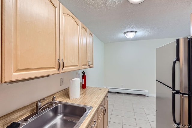 1400 Golden Cir Unit 102, Golden, CO 80401 - kitchen featuring freestanding refrigerator, baseboard heating, light brown cabinetry, a textured ceiling, and light countertops