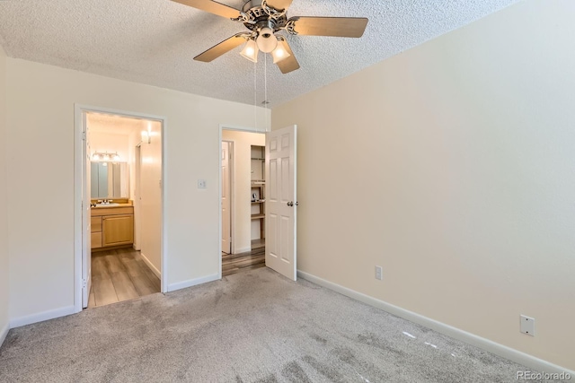1400 Golden Cir Unit 102, Golden, CO 80401 - unfurnished bedroom featuring light carpet, a textured ceiling, connected bathroom, and a ceiling fan