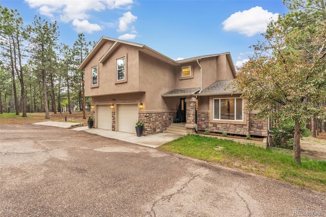 17540 Caribou Dr, Monument, CO 80132 - view of front of property with stone siding, stucco siding, an attached garage, and driveway