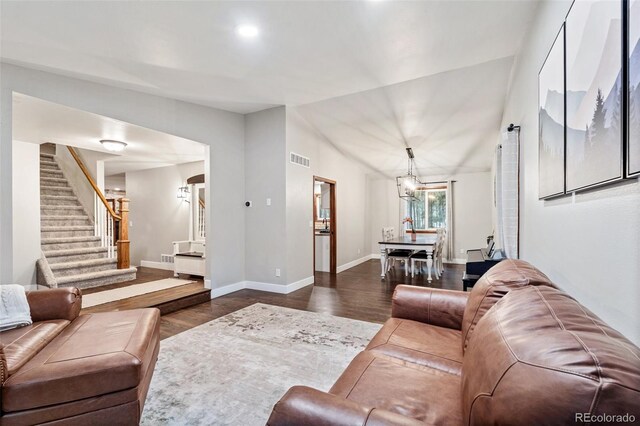 17540 Caribou Dr, Monument, CO 80132 - living area with stairway, dark wood finished floors, baseboards, vaulted ceiling, and a chandelier