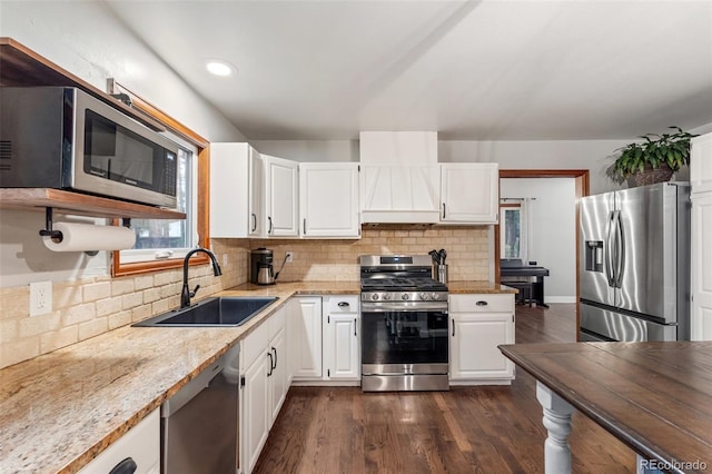17540 Caribou Dr, Monument, CO 80132 - kitchen with appliances with stainless steel finishes, a sink, wall chimney range hood, tasteful backsplash, and recessed lighting
