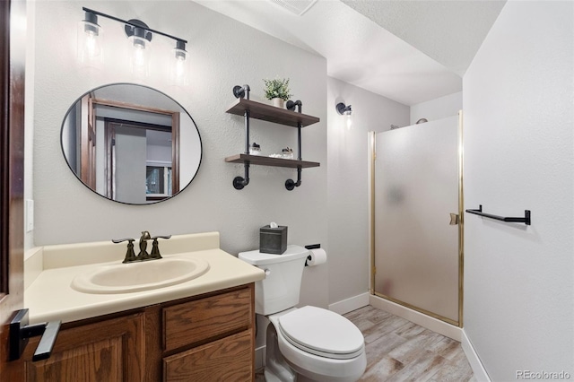 17540 Caribou Dr, Monument, CO 80132 - full bath featuring wood finished floors, a stall shower, vanity, toilet, and baseboards
