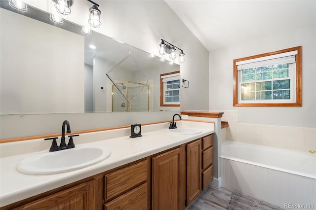 17540 Caribou Dr, Monument, CO 80132 - full bath featuring a bath, wood finished floors, a stall shower, double vanity, and lofted ceiling