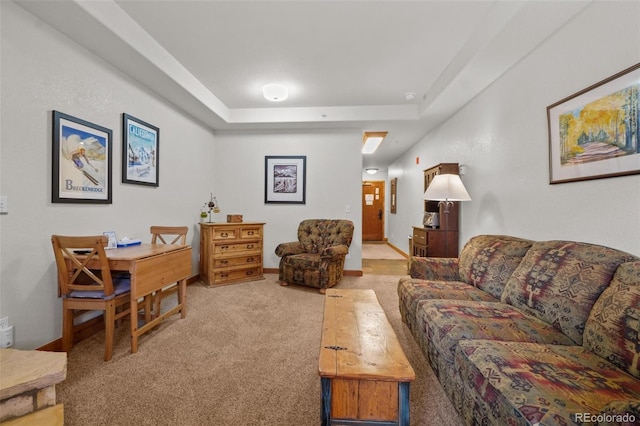 living room with a tray ceiling and light colored carpet