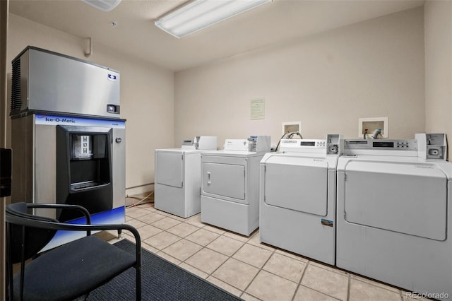 washroom with separate washer and dryer and light tile patterned floors