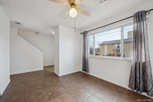 empty room featuring a textured ceiling and ceiling fan