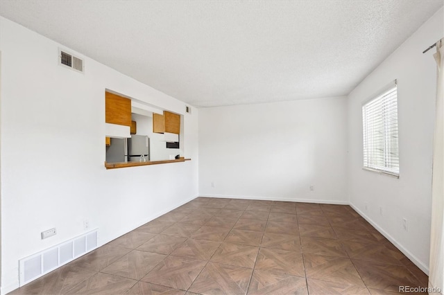 unfurnished room featuring a textured ceiling