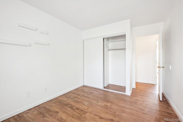 unfurnished bedroom with light hardwood / wood-style floors and a closet