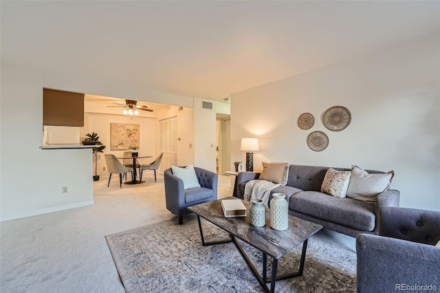 carpeted living room with ceiling fan