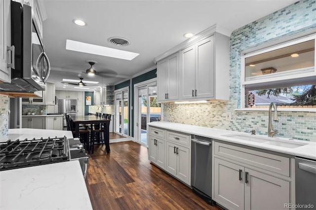 5320 W 62nd Ave, Arvada, CO 80003 - kitchen with appliances with stainless steel finishes, a skylight, ceiling fan, backsplash, and crown molding