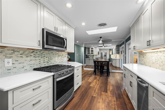 5320 W 62nd Ave, Arvada, CO 80003 - kitchen with stainless steel appliances, a skylight, light countertops, backsplash, and recessed lighting