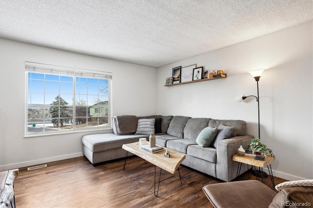 living room featuring dark wood-type flooring and a textured ceiling