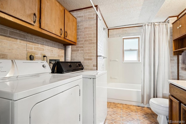 laundry room featuring washer and clothes dryer and a textured ceiling