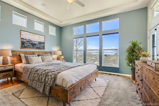 bedroom featuring light hardwood / wood-style flooring, multiple windows, and ceiling fan