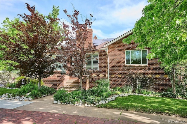 4000 Irving St, Denver, CO 80211 - view of property exterior featuring brick siding, solar panels, a chimney, and a lawn