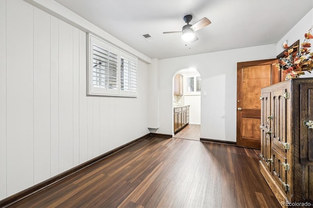4000 Irving St, Denver, CO 80211 - empty room with dark wood-style flooring, arched walkways, ceiling fan, and baseboards