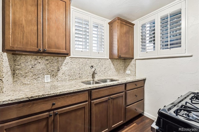 4000 Irving St, Denver, CO 80211 - kitchen with a sink, dark wood-type flooring, black range with gas cooktop, light stone counters, and backsplash